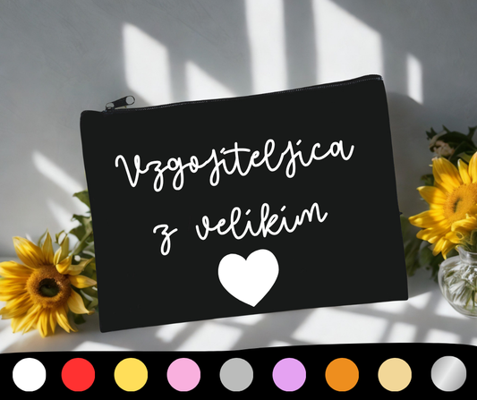 Črna peresnica z belim napisom “Vzgojiteljica z velikim srcem” in belim srčkom, obdana s sončnicami. Spodaj prikazane barvne možnosti napisa.